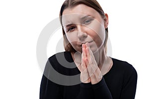 Caucasian pre-teen girl dressed in a black turtleneck asks and pleads on a white background