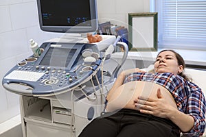 Caucasian pregnant female visiting women`s doctor in maternity center for doing ultrasound scan