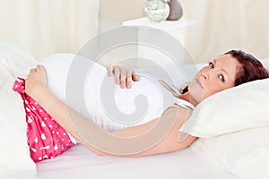 Caucasian pregnant woman resting in her bed