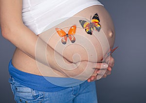 Caucasian pregnant woman stress anxious with butterfly in the stomach studio on gray background