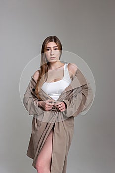 Caucasian pretty girl in raincoat looks at camera. beauty portrait, model tests