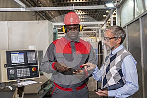 Caucasian Quality Control Inspector Talking To African American CNC Machine Operator In A Factory