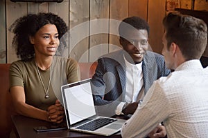 Caucasian realtor consulting black customers at cafe meeting