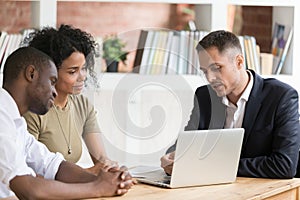 Caucasian realtor meeting with clients couple show houses at laptop photo