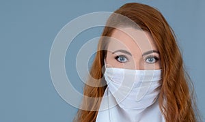 Caucasian redhead woman with blue eyes wearing a mask.