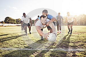 Caucasian rugby player diving to score a try during a rugby match outside on a field. Young male athlete making a dive