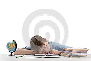 Caucasian schoolboy with glasses is tired of lessons and sleeps at his desk while doing homework. Portrait of tired boy isolated