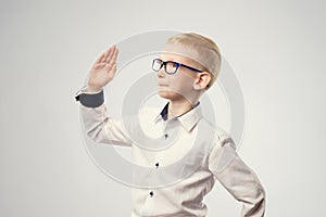 Caucasian schoolboy with his hand raised ready to answer a question.