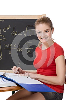 Caucasian schoolgirl by desk studying math exam