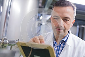 Caucasian scientist in suit checingk readings machine