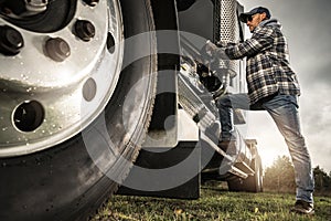 Caucasian Semi Truck Driver Getting Inside To His Tractor Cabin