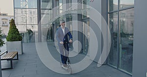 Caucasian Senior Businessman in Formal Wear Suit Riding Electric Scooter