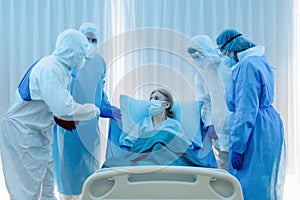 Caucasian senior coronavirus covid-19 infected patient lying on bed in quarantine room of hospital with doctor and medical staffs