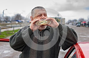 Caucasian senior driver gobbling lyulya kebab in lavash