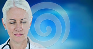 Caucasian senior female doctor wearing stethoscope against blue gradient background