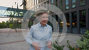 Caucasian senior happy woman running to work in city morning jog outdoors elderly mature female lady CEO smiling old