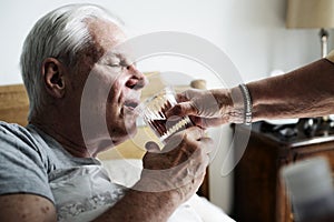 Caucasian senior man drinking water in his bed