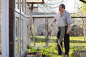 Caucasian Senior man with shovel digging garden bed or farm