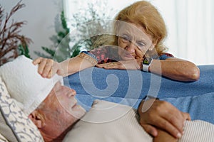 Senior wife taking care husband from sickness at home.