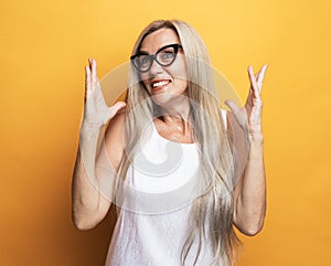 Caucasian senior woman with long white hair isolated on yellow studio background feel surprised by deal