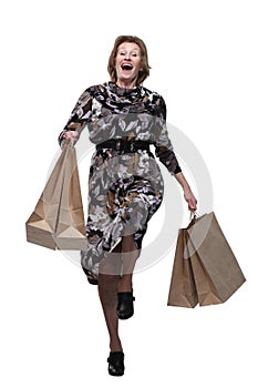 Caucasian senior woman walking with shopping bags smiling at viewer