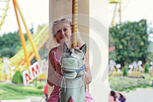 Caucasian Senior woman wear pink sun glasses on merry go round