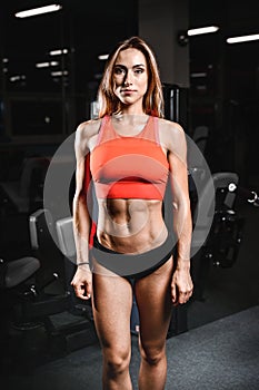 Caucasian fitness female model in gym close up abs