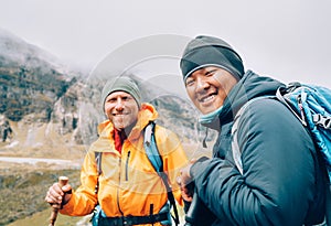 Caucasian and Sherpa men with backpacks together smiling at camera Makalu Barun Park trekking route. Mera peak climbing