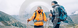 Caucasian and Sherpa men with backpacks with trekking poles together smiling enjoying Mera peak climbing acclimatization walk