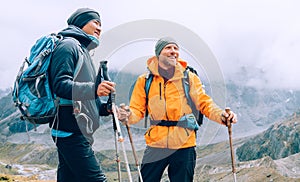 Caucasian and Sherpa men with backpacks with trekking poles together smiling enjoying Mera peak climbing acclimatization walk