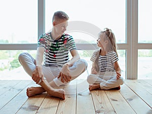 Caucasian siblings brother and sister doing yoga at home by the window.