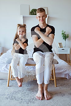 Caucasian siblings - teenager boy brother and little girl sister in bedroom modern loft interior.