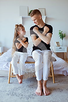 Caucasian siblings - teenager boy brother and little girl sister in bedroom modern loft interior.