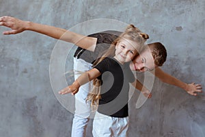 Caucasian siblings - teenager boy brother and little girl sister playing in aircraft in modern loft