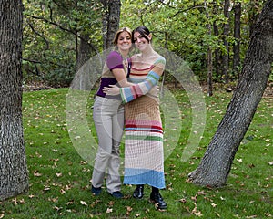 Caucasian sisters hugging each other in an affectionate pose outdoors in Edmond, Oklahoma.