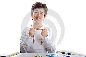 Caucasian smooth-skinned boy prays holding Rosary beads with bot