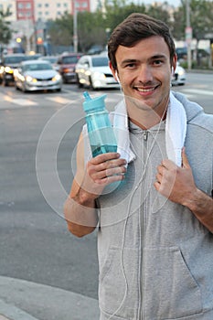 Caucasian Sport man drinking water bottle in New York City. Male runner sweaty and thirsty after run in the busy city street