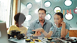 Student asking teacher about code and pointing at laptop screen. Edification.