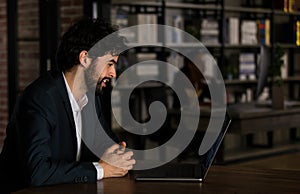 Caucasian successful professional diligent bearded and mustache male businessman in formal suit sitting at work desk typing laptop