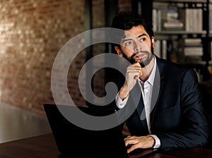 Caucasian successful professional diligent bearded and mustache male businessman in formal suit sitting at work desk typing laptop