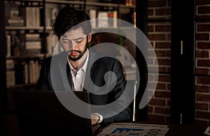 Caucasian successful professional diligent bearded and mustache male businessman in formal suit sitting at work desk typing laptop