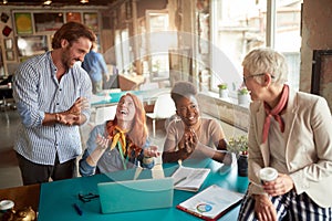 Caucasian team, different ages, talking, smiling, having a good time while working