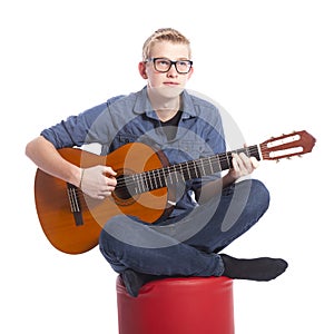 Caucasian teen boy in blue wears glasses and plays the classical