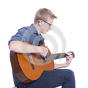 Caucasian teen boy in blue wears glasses and plays the classical
