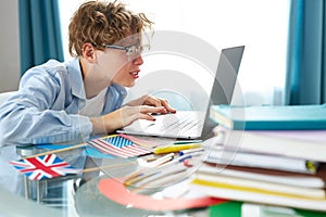 Caucasian teen boy sit with laptop, studying online