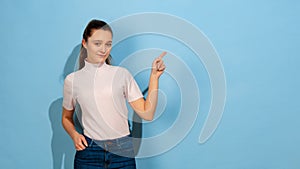 Caucasian teen girl portrait isolated on blue studio background