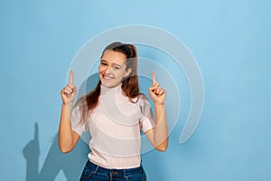 Caucasian teen girl portrait isolated on blue studio background