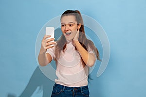 Caucasian teen girl portrait isolated on blue studio background