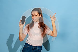 Caucasian teen girl portrait isolated on blue studio background