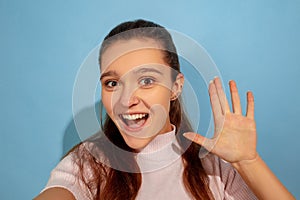 Caucasian teen girl portrait isolated on blue studio background